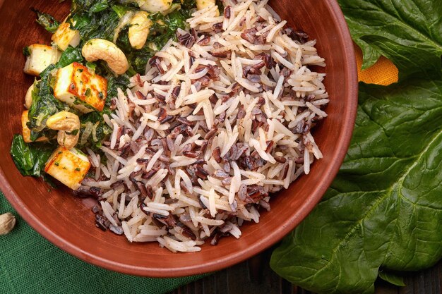 Foto tigela de arroz com salada de espinafre, tofu e castanha de caju close-up