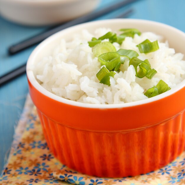 Foto tigela de arroz cozido com cebola verde