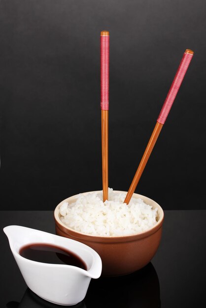 Foto tigela de arroz e pauzinhos em fundo cinza