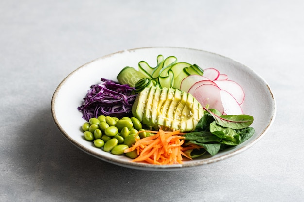 Tigela de Buda com abacate edamame feijão pepino repolho roxo cenouras rabanetes e espinafre vegetais s