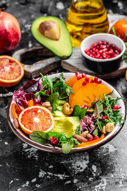 Tigela de Buda com vegetais, frutas e sementes em um fundo escuro. imagem vertical