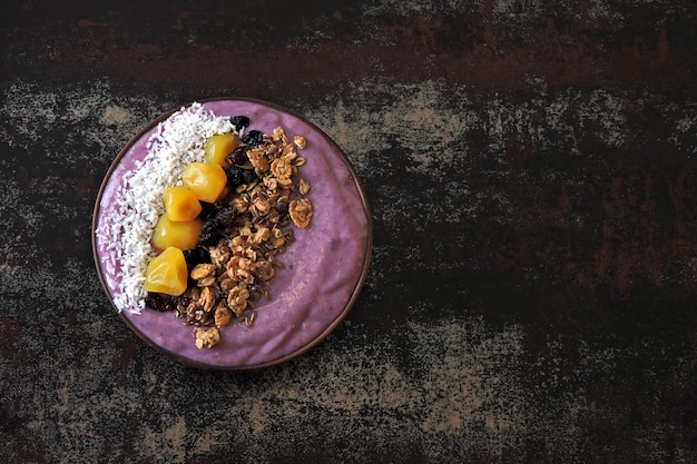 Tigela de café da manhã brilhante com batido de próton roxo e granola. smoothie de próton roxo.