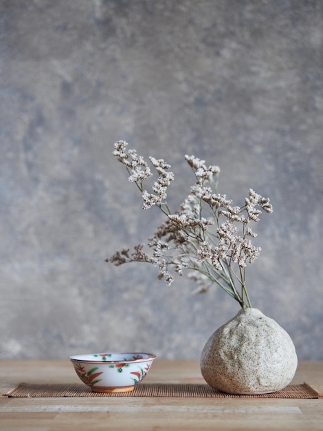 Tigela de cerâmica com flores secas em vaso