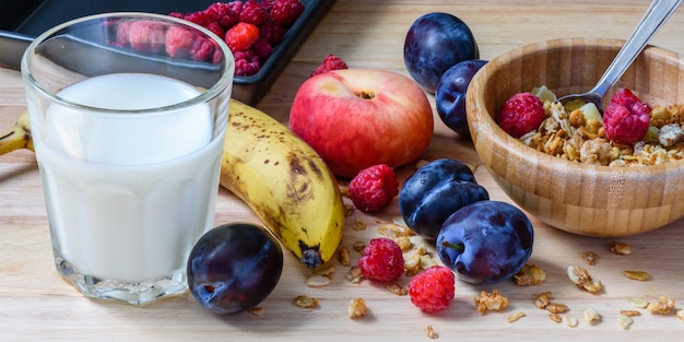 Tigela de cereais com frutas, frutas e leite no café da manhã