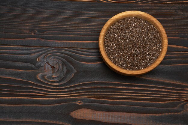 Tigela de closeup de sementes de chia natural orgânico em fundo de madeira ou mesa