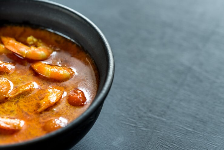 Foto tigela de curry amarelo tailandês com frutos do mar