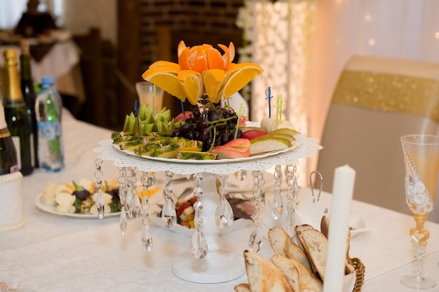 Tigela de frutas na mesa de casamento Peras maçãs uvas kiwi