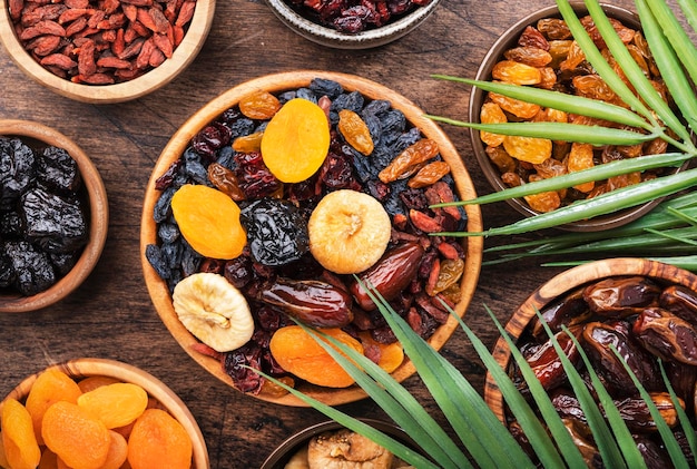 Tigela de frutas secas Lanche de comida saudável mistura orgânica seca ao sol de damascos figos passas datas e outros na mesa de madeira vista superior