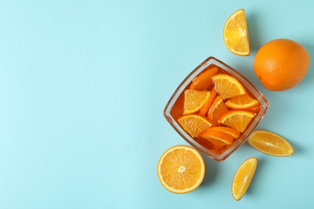 Tigela de geleia de laranja com rodelas de laranja em fundo azul