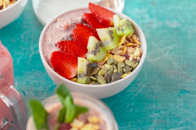 Foto tigela de granola caseira com iogurte e frutas frescas na madeira