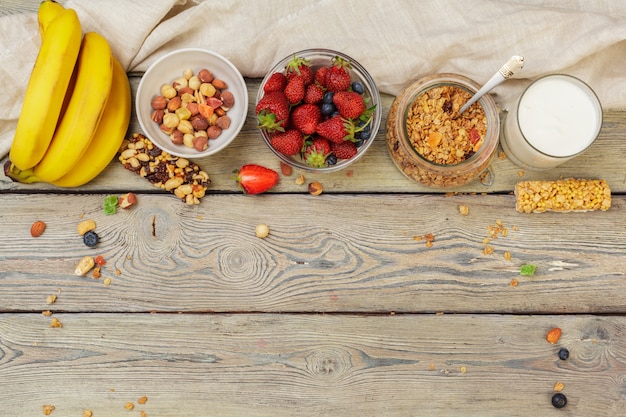 Tigela de granola caseira com iogurte e frutas frescas na madeira