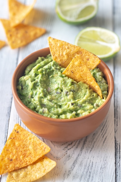 Tigela de guacamole com batatas fritas de pacote