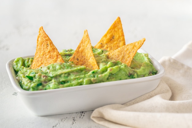 Tigela de guacamole com batatas fritas de pacote