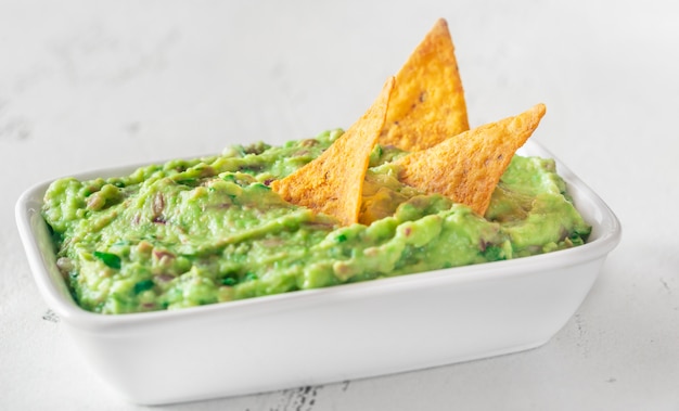 Tigela de guacamole com batatas fritas de pacote