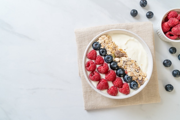 tigela de iogurte caseiro com framboesa, mirtilo e granola - estilo de comida saudável