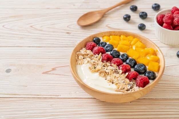 tigela de iogurte caseiro com framboesa, mirtilo, manga e granola - estilo de comida saudável