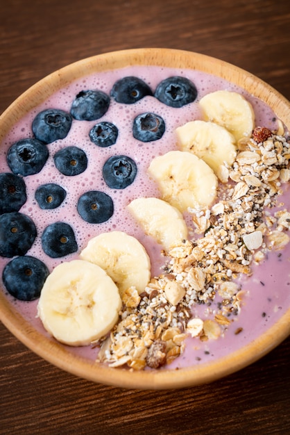 tigela de iogurte ou vitamina de iogurte com baga azul, banana e granola - estilo de comida saudável