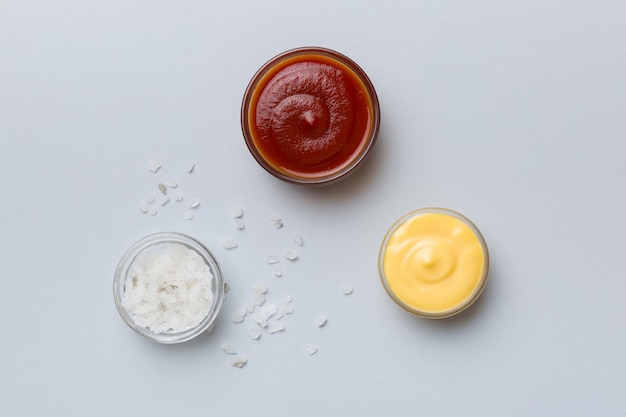 Tigela de ketchup salgado e molho de queijo na vista superior de fundo colorido com espaço de cópia