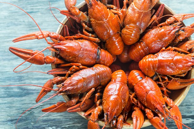 Tigela de lagostins cozidos na mesa de madeira