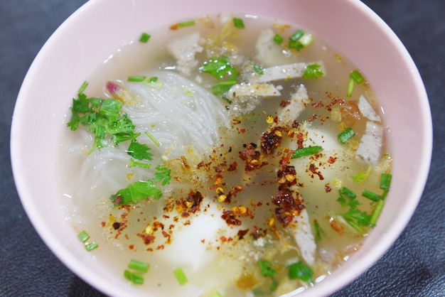 Tigela de macarrão delicioso - close-up de sopa de macarrão aletria picante com ovo de porco e vegetais na tigela tradicional comida de estilo tailandês e chinês da Ásia