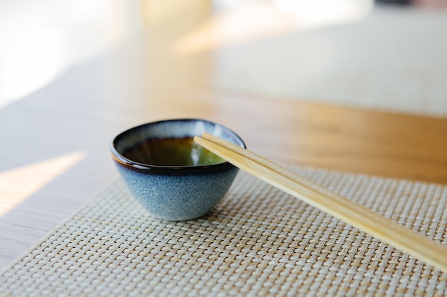 tigela de molho com pauzinhos de sushi na mesa de restaurante