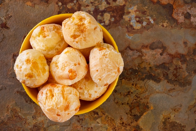 Tigela de pães de queijo em uma pedra de ardósia enferrujada.