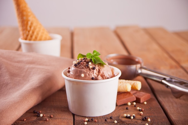 Tigela de papel de sorvete de chocolate, cone de waffle e colher de sorvete