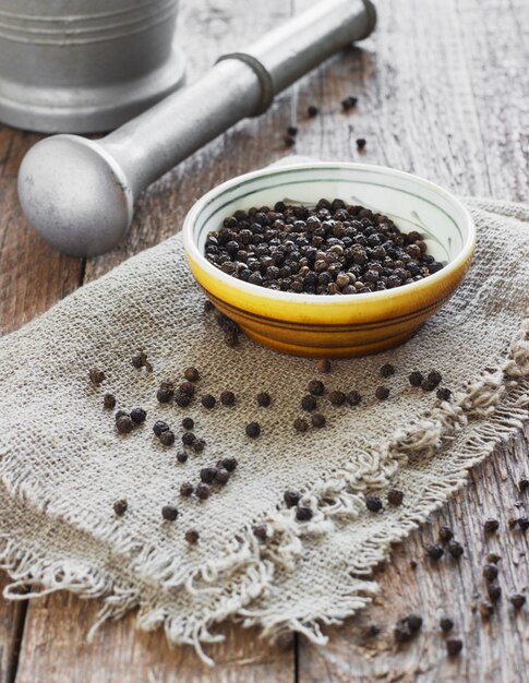 Tigela de pimenta preta na mesa de madeira