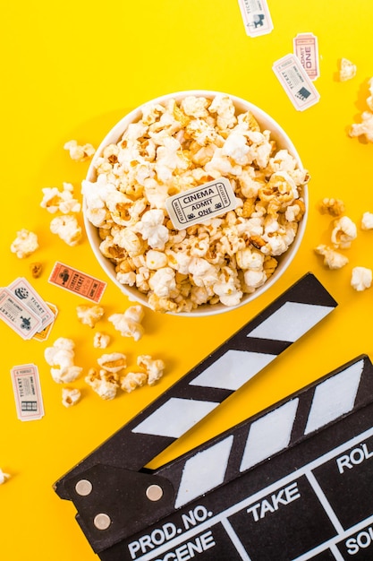 Tigela de pipocas salgadas em um fundo amarelo. Conceito de lanche de cinema. Vista superior plana