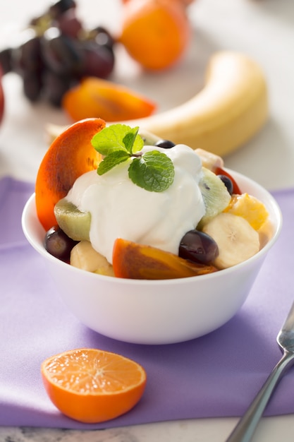 Tigela de salada de frutas frescas saudáveis na toalha de mesa roxa