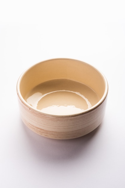 Tigela de servir de cerâmica marrom vazia, isolada sobre uma superfície branca ou cinza