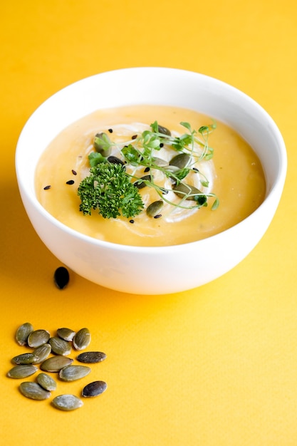 Tigela de sopa de abóbora com folha verde