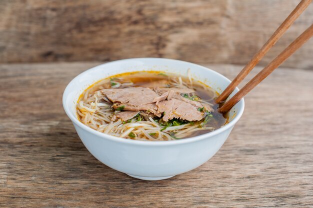 tigela de sopa de carne tradicional vietnamita Pho Bo no fundo escuro de madeira velho