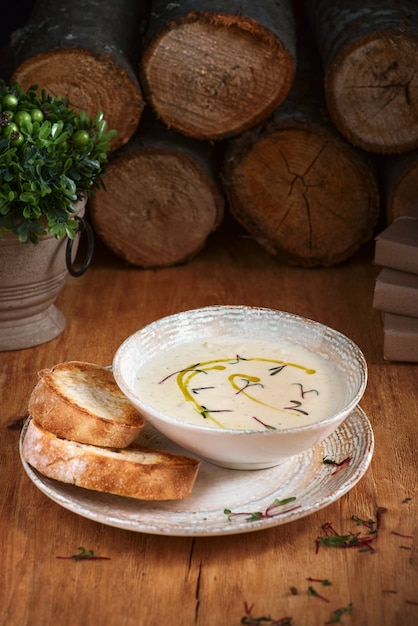 Tigela de sopa de creme com óleo. Na mesa de madeira fechar