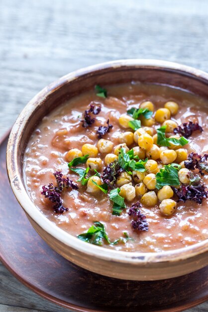 Tigela de sopa de grão de bico em cima da mesa de madeira