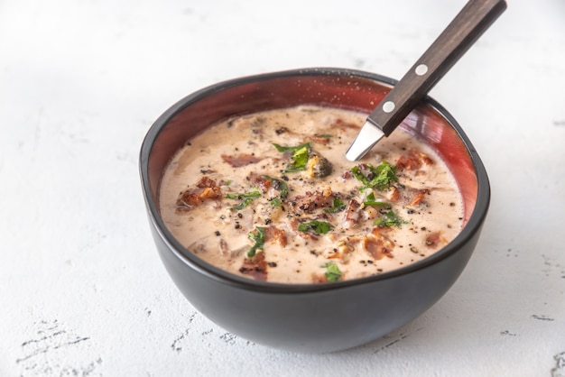 Tigela de sopa de mariscos guarnecida com bacon picado e salsa fresca