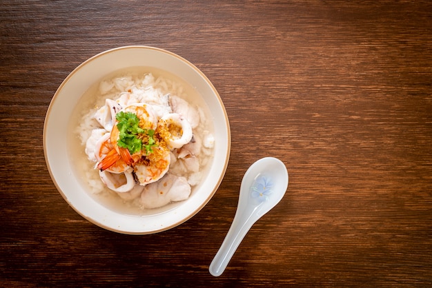 tigela de sopa de mingau ou arroz cozido com frutos do mar (camarão, lula e peixe)