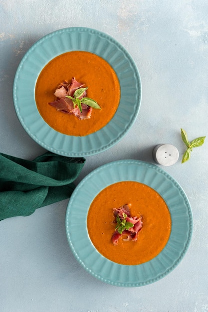 Tigela de sopa de tomate assado com creme e presunto