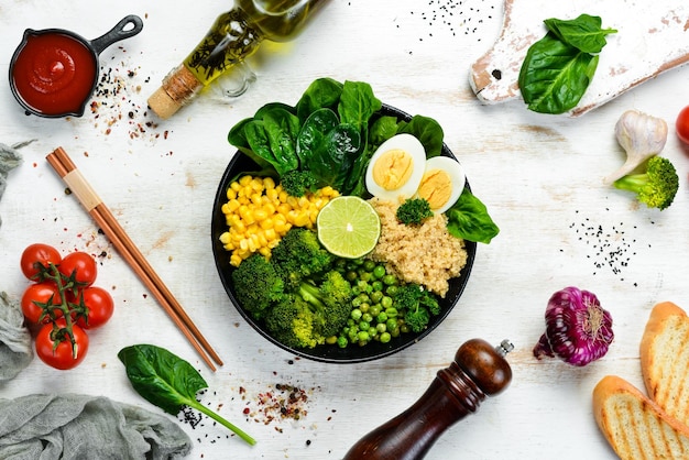 Tigela de vegetais verdes buda quinoa ervilhas verdes milho espinafre brócolis ovo comida saudável vista superior espaço livre para o seu texto
