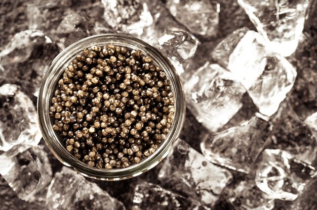 Tigela de vidro com caviar preto com gelo picado