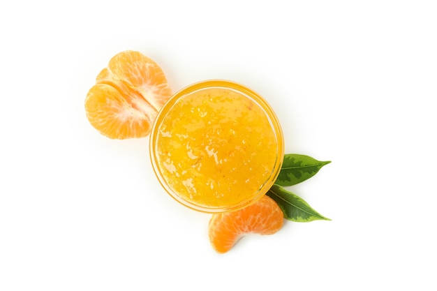 Tigela de vidro com geléia de tangerina e ingredientes isolados no fundo branco.