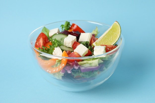 Tigela de vidro com salada fresca em azul