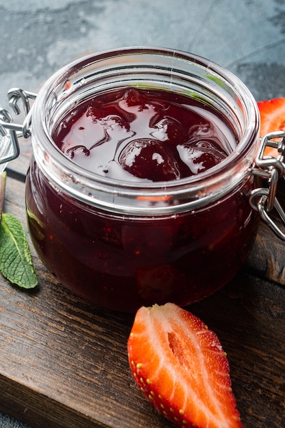 Tigela de vidro pequena com geleia de frutas vermelhas sobre mesa cinza