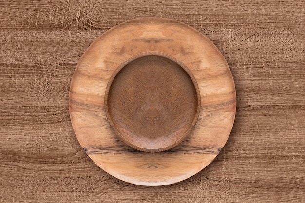 Tigela e prato de madeira na mesa de madeira Conceito de madeira