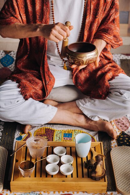 Tigela tibetana nas mãos de um homem durante uma cerimônia do chá