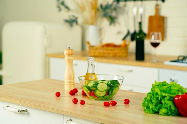 Tigela transparente com salada de legumes legumes frescos na mesa na cozinha Conceito de comida Comida saudável