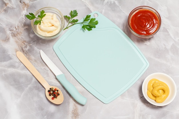 Tigelas com ketchup mostarda e molho de queijo na mesa da cozinha