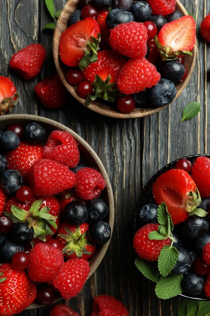 Tigelas com mistura de frutas silvestres em madeira