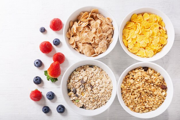 Tigelas de flocos de milho granola de cereais e frutas frescas para café da manhã vista superior