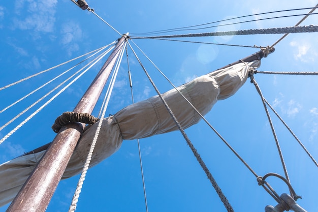 Tigging und Maste eines alten Segelschiffs gegen den blauen Himmel mit Wolken. kopieren sie platz.